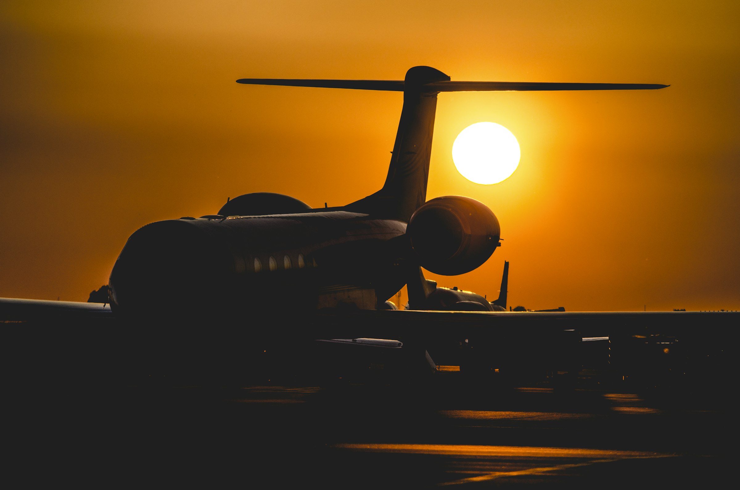 Private aircraft silhouetted against a golden East African sunset on the tarmac